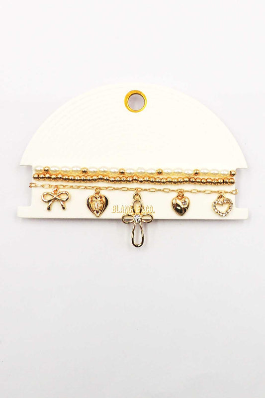 Set of Three Gold and Pearl Stretch Bracelets with Bow, Heart, and Cross Charms