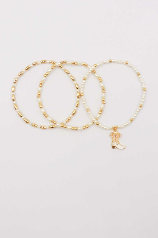 Set of Three Gold and Pearl Stretch Bracelets with Light Pink Bow on White Cowboy Boot Charm